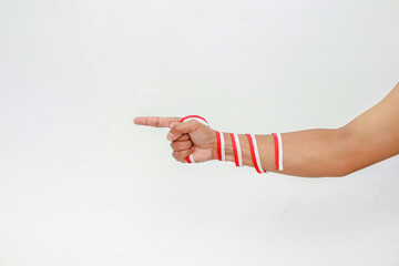 Hand pointing with red and white ribbons symbolizing Indonesian Independence Day celebration