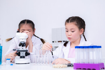 Learning and education for student in classroom, children focus on pipette handling and microscope...