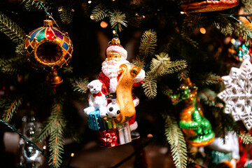 Santa ornament with gifts and polar bear on decorated tree for celebration, holiday and gift-giving...