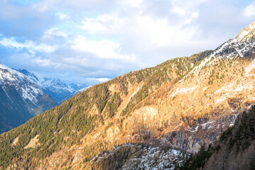 Sunlit snowy mountain hills with evergreen trees in Chamonix for seasonal change, warmth and alpine...