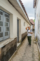 Asian man enjoying a joyful walk through the heritage streets of Kotagede. Old city exploration,...