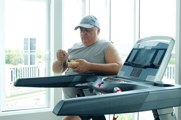 An overweight man standing and eating a fruit salad — weight loss exercise.