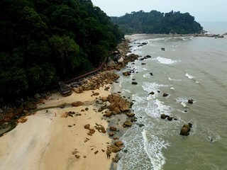 Beach landscape with hills and rock formations during noon and sunset