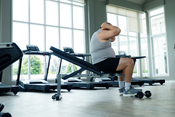 An overweight man exercising at the gym — working out for better health and weight loss.