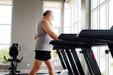 An overweight man exercising at the gym — working out for better health and weight loss.