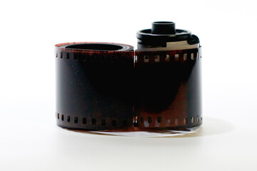 Close up of roll film strip 35mm with canister isolated on white background