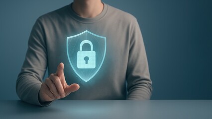 Seated person interacts with a floating holographic shield and padlock, representing cybersecurity in a calm, bank safety and protection