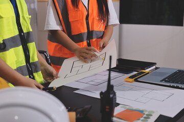 Closeup of team of industrial engineers meeting analyze machinery blueprints consult project on...