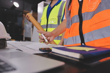 Closeup of team of industrial engineers meeting analyze machinery blueprints consult project on...