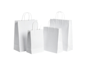 Group of four white paper carrier bags large and small with twisted handles for shopping or gifts.