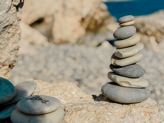 Stacked flat round stones sculpture on Aphrodite’s Beach in Cyprus symbolizing balance, harmony, and natural art in a peaceful coastal setting © Katarzyna Ledwoń