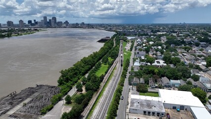 Aerial view of Mississippi River with New Orleans, Louisiana city skyline on horizon under clouds with rain storm in distance