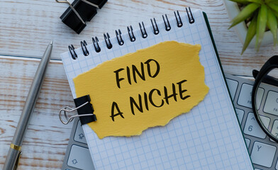 A notebook with a yellow piece of paper that says Find a Niche