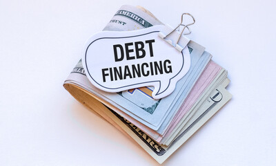 A stack of money with a sign that says Debt Financing