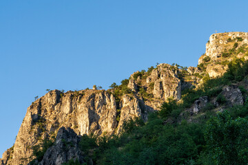 Sun-Kissed Cliff at Sunset: Warm Light Against Blue Sky