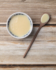 Condensed milk in a bowl over wooden table