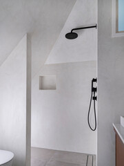 Modern bathroom shower area with black rainfall showerhead, white walls, and built-in storage niche