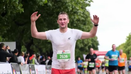 Triumphant runner crosses finish line at outdoor marathon event