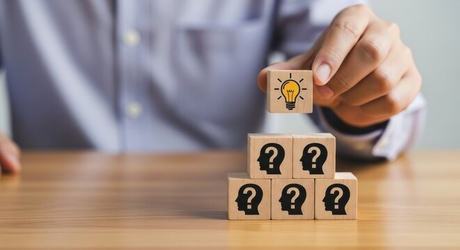 Hand placing lightbulb block on question mark blocks symbolizing creative problem solving and innovative solutions