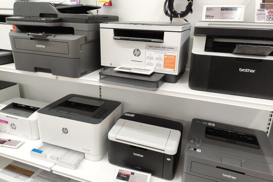 Rome, Italy - July 15, 2025: Various printer models displayed on a retail shelf, showcasing HP and Brother brands, highlighting features and technology for consumer choice