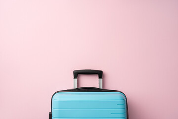 Minimalist composition featuring a light blue suitcase on a soft pink backdrop, evoking travel vibes