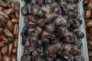 Date fruit on market stall fresh natural tropical healthy snack. Close up of ripe brown dates displayed on rustic market stall symbolizing abundance