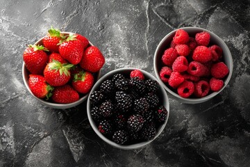 stawberries, raspberries and blackberries in separate bowls