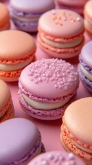 Fototapeta premium Assortment of pastel colored french macarons with delicate sprinkles on a pink background