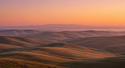 Peaceful undulating hills under a warm sunset creating a sense of serenity