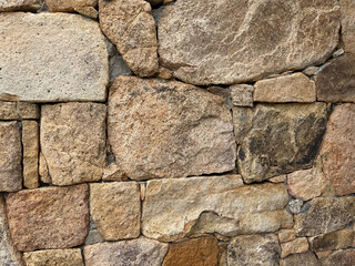 Close-up of irregular granite stones forming an old traditional wall