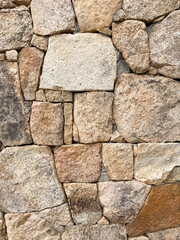 Close-up of irregular granite stones forming an old traditional wall