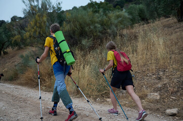 Active Couple Hiking in Nature Carrying Trekking Gear
