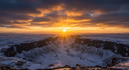 Magnificent sunrise over a snowy canyon landscape with radiant sunlight piercing the clouds