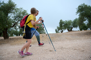 Active Young Hikers Trekking in Nature with Walking Poles