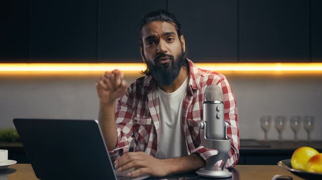 Portrait of popular Indian blogger streaming video game on laptop, hobby content