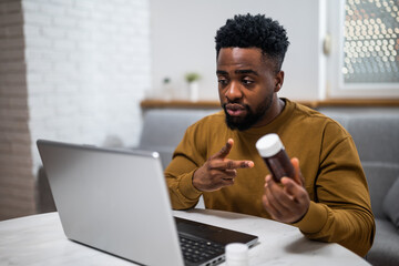 African-American man having online medical support and prescription discussion with doctor via...