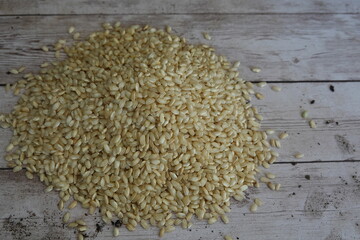 Pile of integral rice grains resting on wooden table