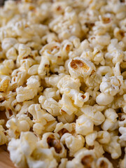 Butter salted popcorn on wooden table.