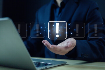 Businessman showing exclamation mark on hand in front of laptop. business development, warning notification, personal data protection, notification, error warning, maintenance