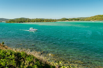 View from above of the beautiful Conchas beach, near the city of Cabo Frio, with white sand beaches, blue sky, sea with clear waters in shades of green and blue, with mountains in the background