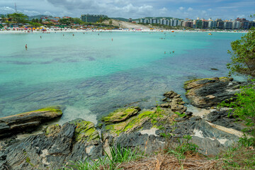 View of the São Mateus Fort with part of the fort's beach full of large rocks, the sea with crystal clear waters around, located in Cabo Frio, coast of Rio de Janeiro, Brazil.
