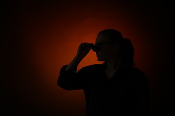 Silhouette of woman posing on dark gradient background, space for text