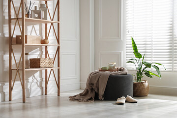 Stylish pouf with tea set at home