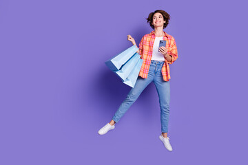 Full body portrait of pretty young lady jump shop empty space wear shirt isolated on purple color...