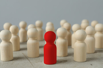 Dismissal. Red figure among wooden ones on light table