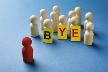 Dismissal. Red standing in front wooden ones with word Bye made of cards on blue background