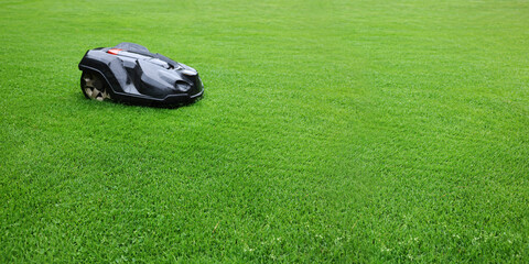 Lawn mower on lush bright green grass outdoors, banner design