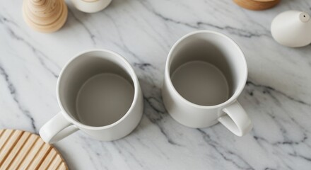 Elegant white ceramic mugs mockup resting on a sleek marble surface with decor