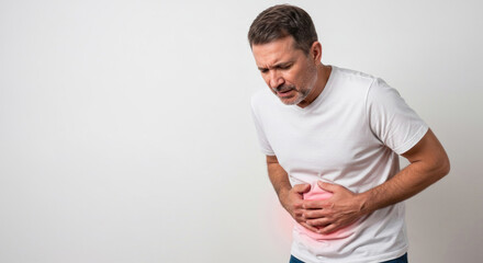 middle aged man in white t-shirt holding stomach with pained expression. abdominal pain concept with red highlight indicating discomfort. healthcare, medical article, illness awareness.