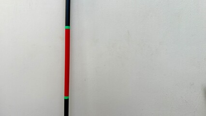 A bo staff isolate black and red color on the white wall.